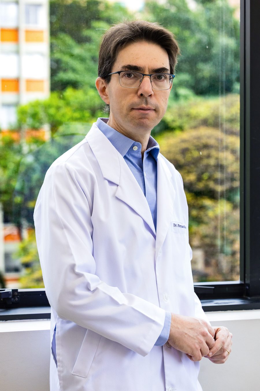 Dr. Fernando Danelon Leonhardt, de jaleco, em seu consultório